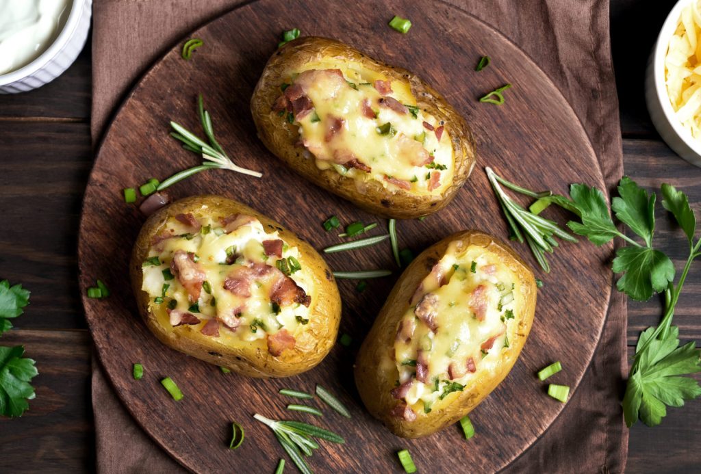Gevulde Aardappelen met gesmolten kaas, bacon, zure room en bieslook garnering